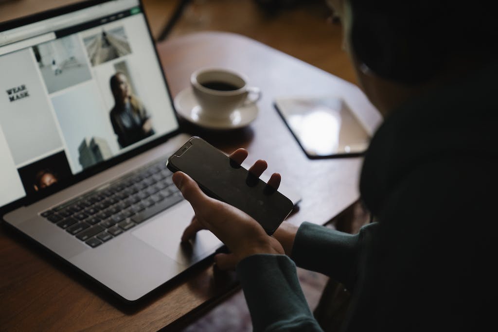 Man using laptop and smartphone at workplace